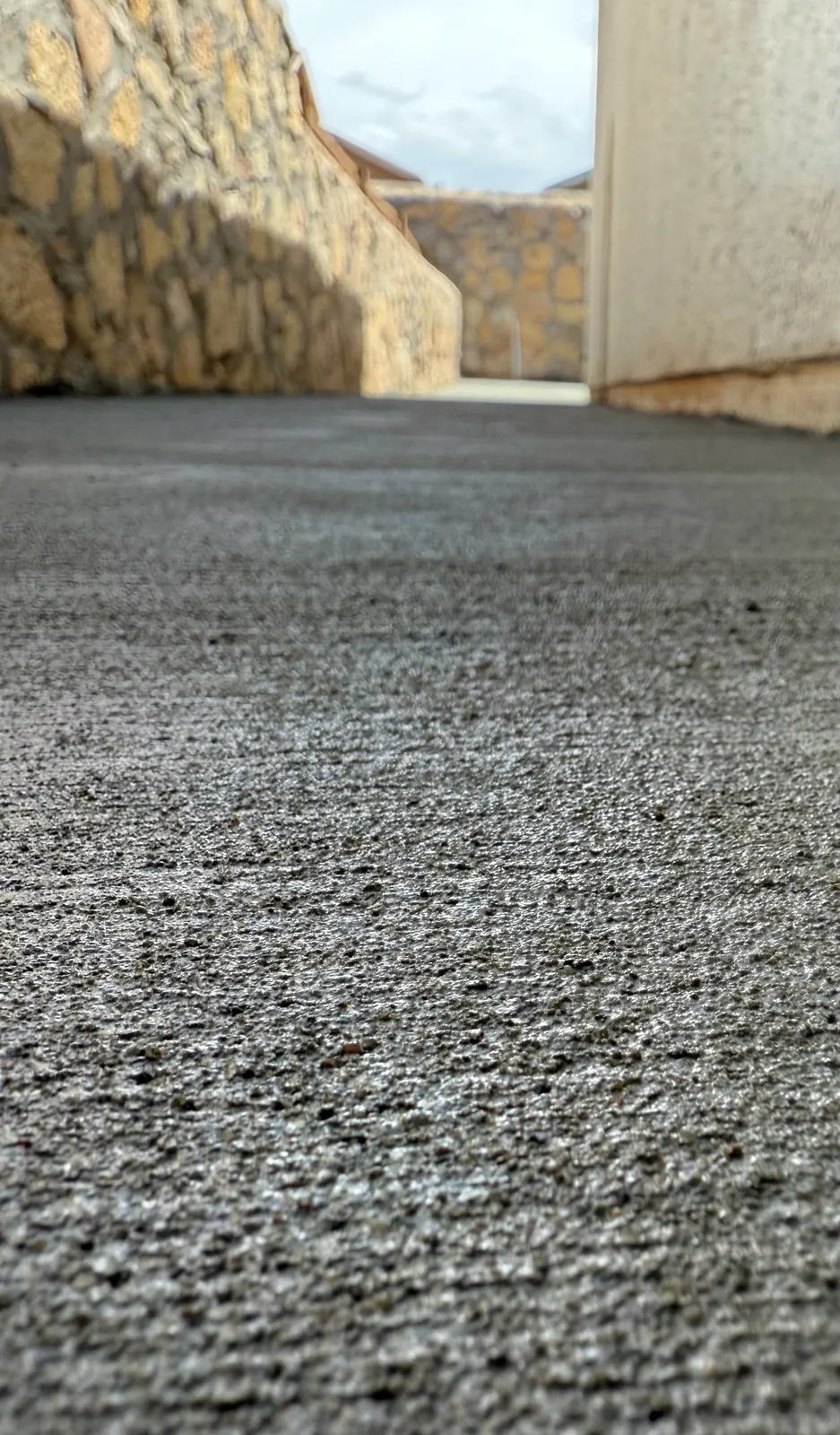 Exposed aggregate concrete driveway with a smooth rock border in El Paso