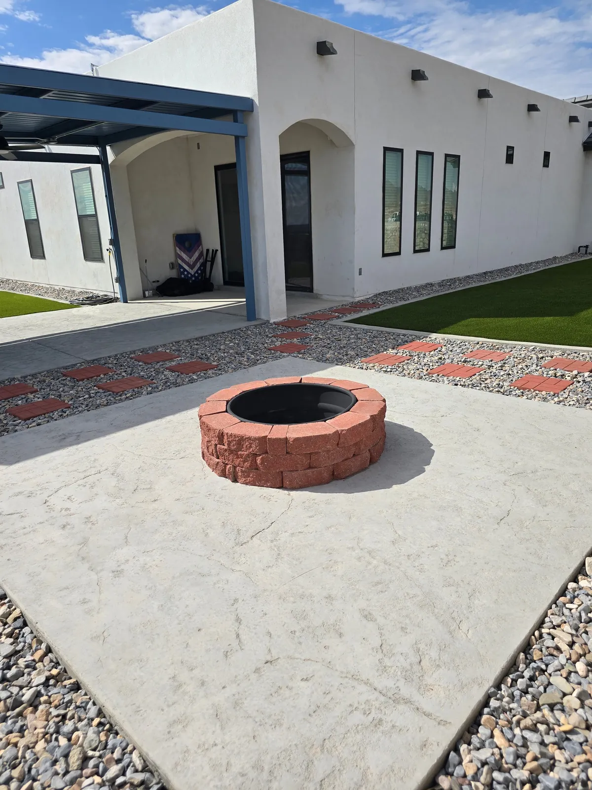 Completed concrete and paver fire pit patio surrounded by desert landscaping