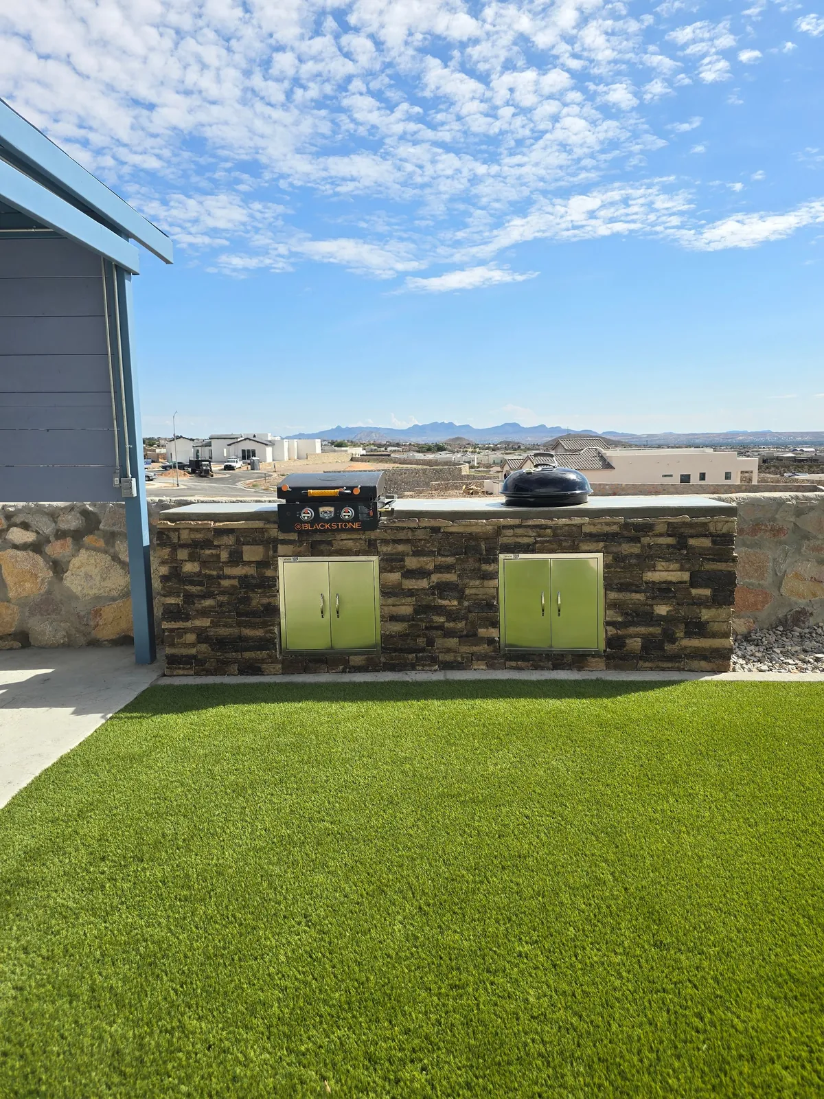 Second angle of a completed El Paso Elements outdoor kitchen with masonry island and grill