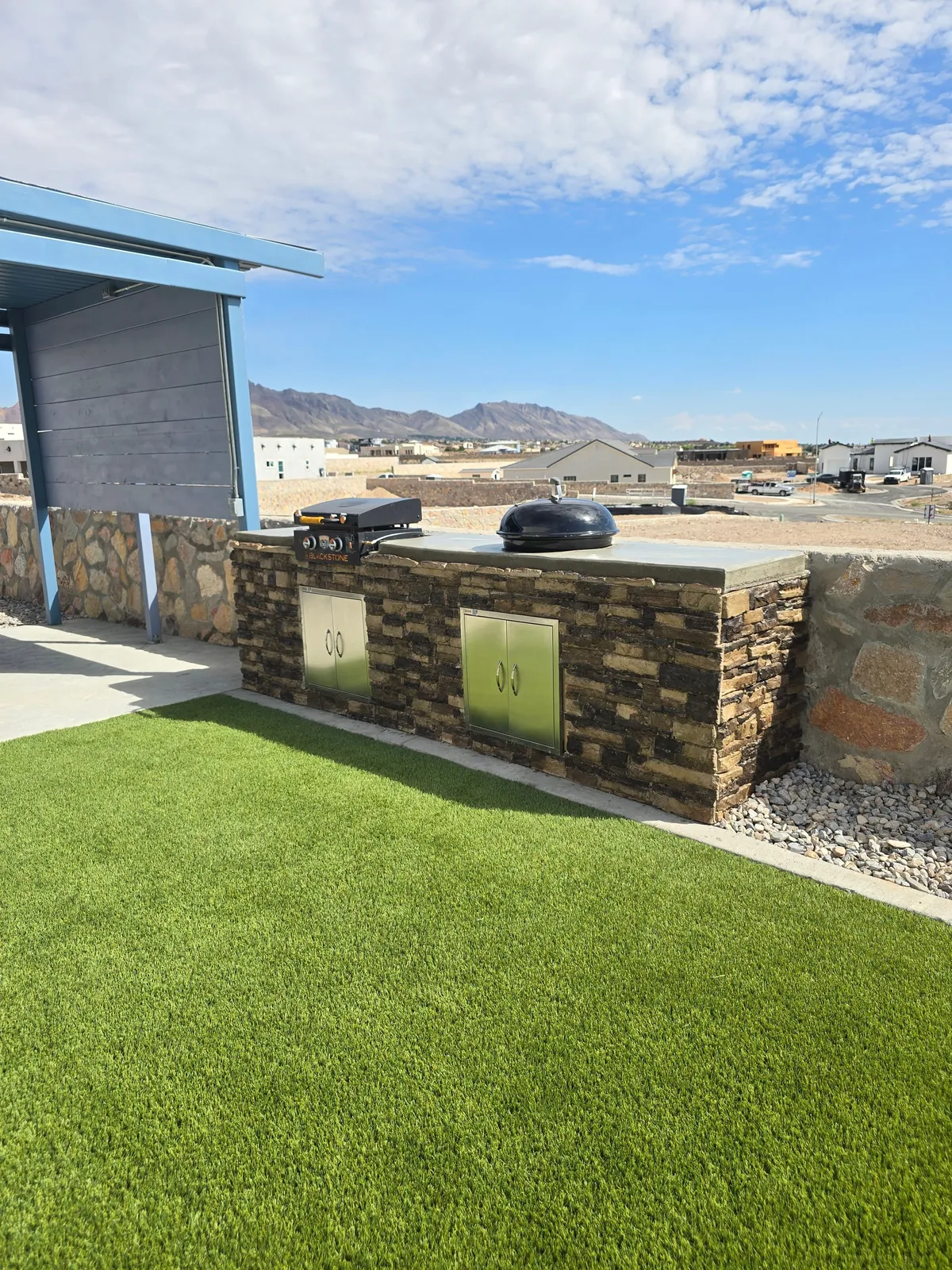 Completed outdoor kitchen and shaded seating area in an El Paso backyard built by El Paso Elements
