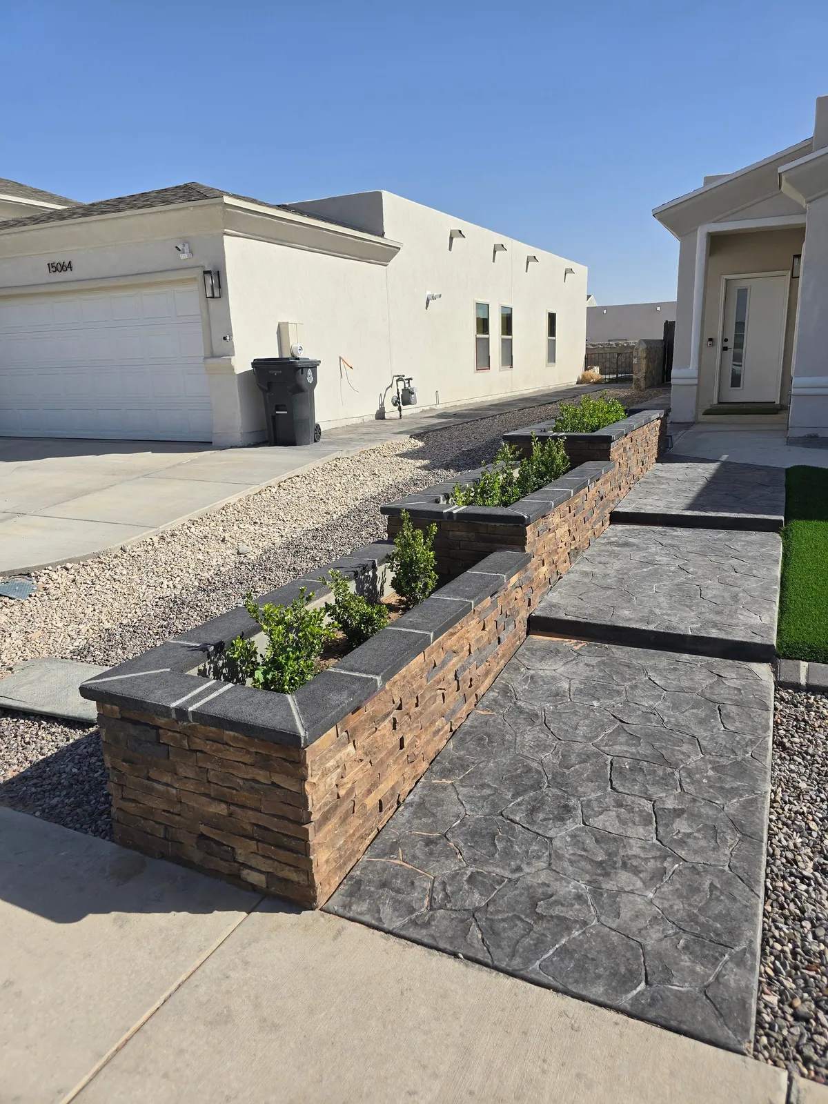 Artificial turf with decorative planter beds in a completed El Paso landscape