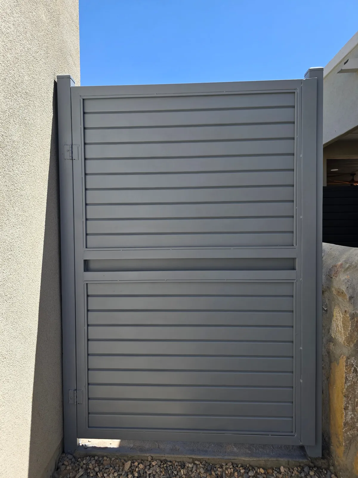 Completed custom metal slatted gate installed within a property wall by El Paso Elements