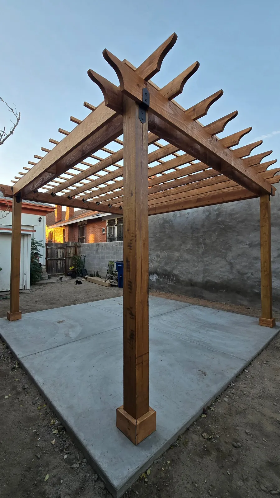 Finished wood pergola with integrated details shading a concrete patio built by El Paso Elements